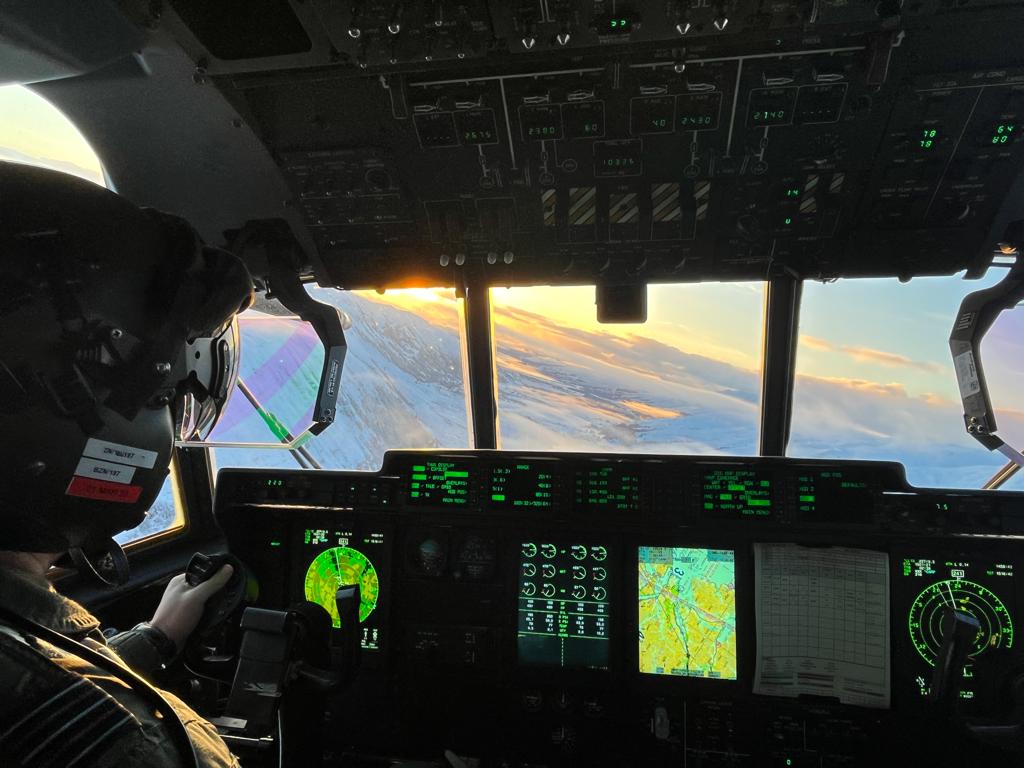 Hercules and Voyager aircraft from the Air Mobility Air Wing conduct joint training above a snowy UK.
